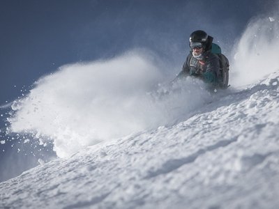 Deine Ferienwohnung in Neustift ✓ Skifahrer fährt schnell durch frischen Pulverschnee am sonnigen Berg