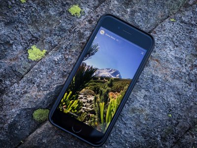 Unterkunft in Neustift im Stubaital: die beste Lage ⬤ Smartphone mit Berglandschaft auf dem Bildschirm auf felsigem Untergrund