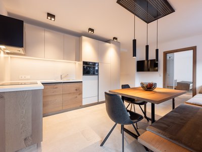 Corona-Maßnahmen: gut gewappnet in deine Fewo im Stubaital ✓ Moderne Küche und Essbereich mit Holzmöbeln und schwarzen Stühlen