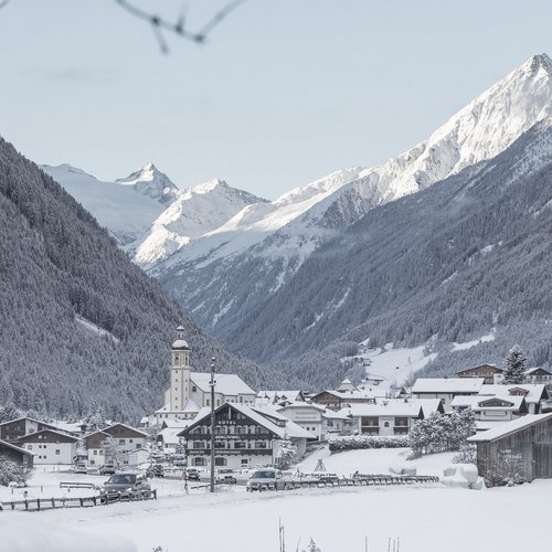 Your holiday apartment in Neustift ✓ Snowy mountain village with church tower and snow-covered Alps in background