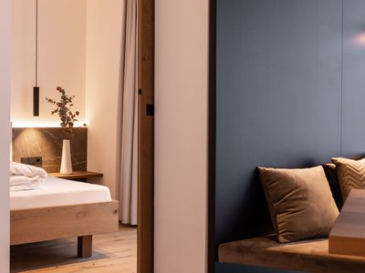 Ferienwohnung in Neustift im Stubaital mit Style ❥ Modernes Schlafzimmer mit Holzmöbeln und Sitzbereich mit Kissen