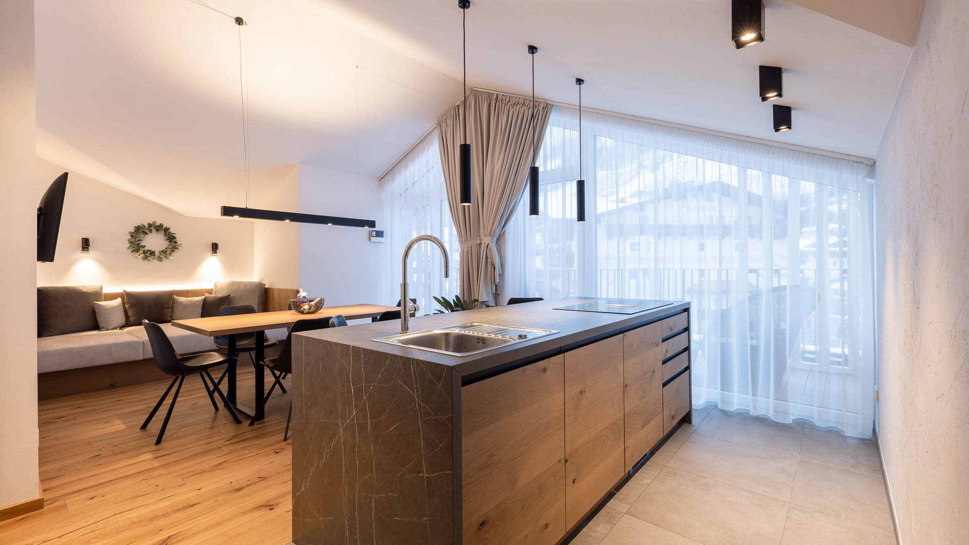 Ferienwohnung in Neustift im Stubaital mit Style ❥ Moderne Küche mit Esstisch, Sofa und großen Fenstern mit weißen Vorhängen