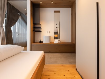 Ferienwohnung in Neustift im Stubaital mit Style ❥ Modernes Schlafzimmer mit Holzboden und integriertem Waschbeckenbereich