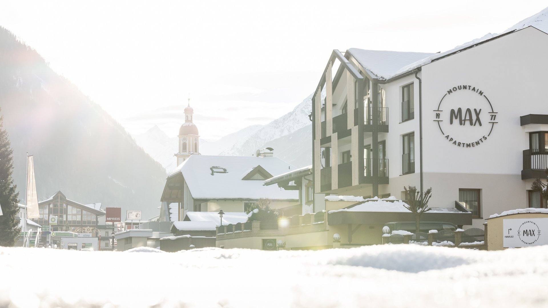 Your holiday apartment in Neustift ✓ Snow-covered mountain village with apartments and church in the background
